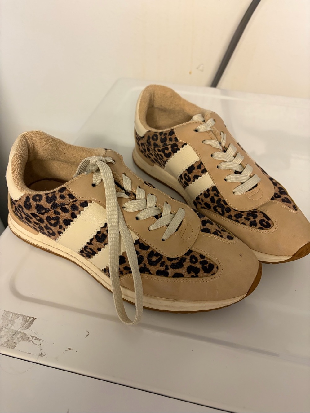 Three athletic shoes: Dolce Vita (animal print) Reebok and Adidas.
